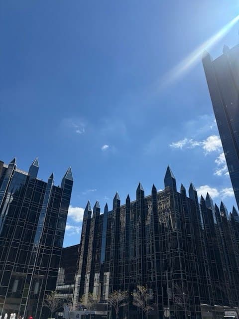 Downtown Pittsburgh architecture with sharp glass building lines against a blue sky